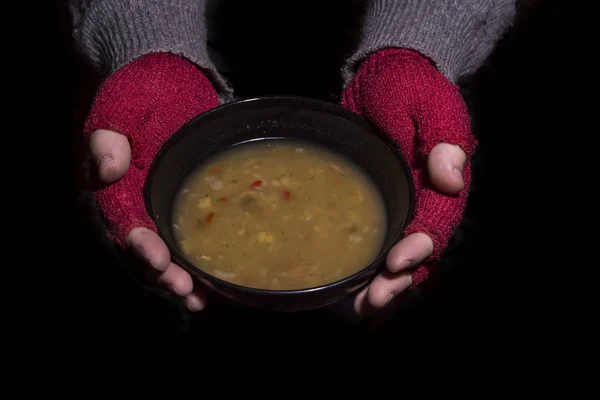 Håller en skål med soppa. Fattigdom-konceptet — Stockfoto