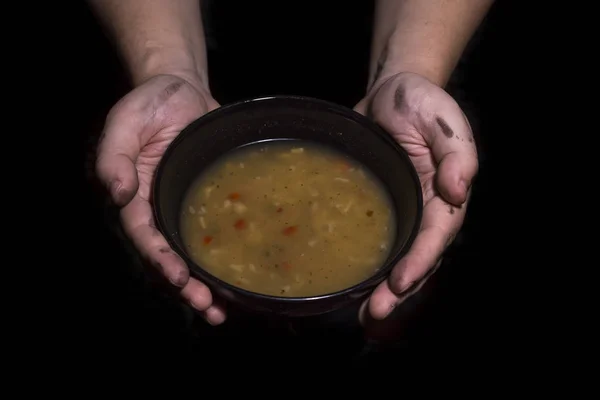 Con in mano una ciotola di zuppa. Concetto di povertà — Foto Stock