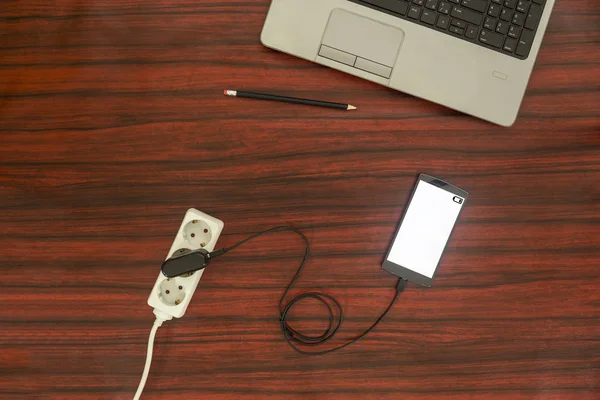 Концепция зарядки мобильных телефонов - Телефон подключен к электрической розетке — стоковое фото