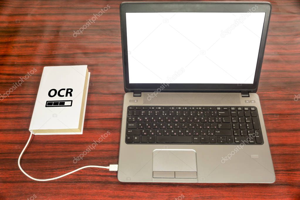 Optical character recognition concept. Book and laptop