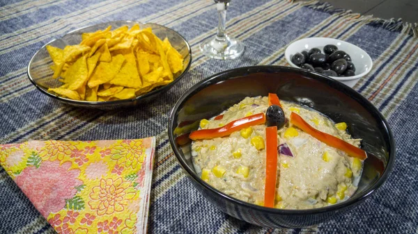 Ciotola di insalata di tonno, tortilla chips, olive e bicchiere di vino rosso — Foto Stock