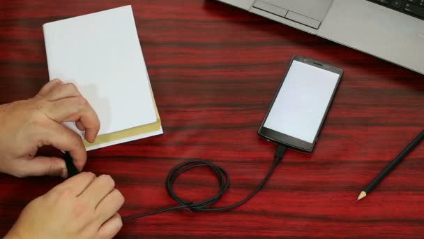 Laying next to a laptop and pencil on a desk. — Stock Video