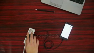 Telefon elektrik soketine ve güç uzatma kablosuna bir kablo ve adaptör aracılığıyla bağlı.