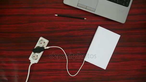 Book connected to a power outlet. — Stock Video