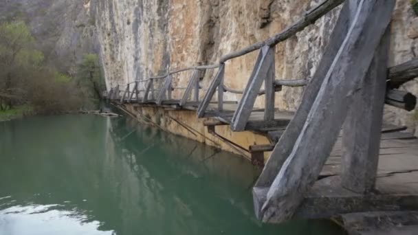Furcht einflößende und gefährliche Holzbrücke über einen Fluss. — Stockvideo