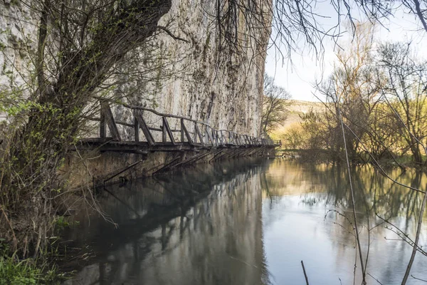 Bir nehir üzerinde korkunç ve tehlikeli ahşap köprü.
