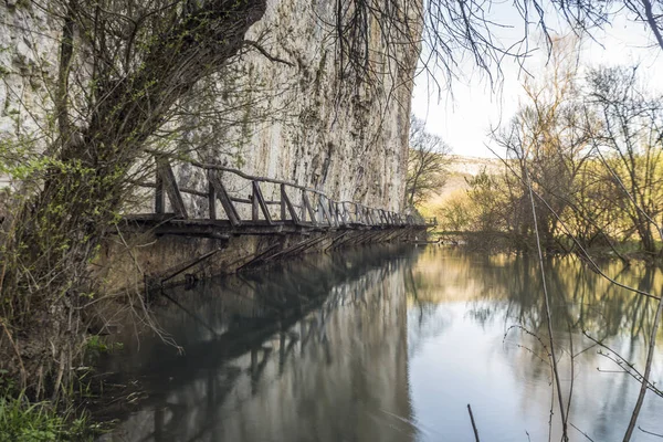 Bir nehir üzerinde korkunç ve tehlikeli ahşap köprü.