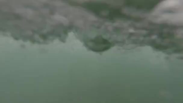 Monter les vagues à venir et plonger sous l'eau pour voir les vagues et la lumière du soleil 
