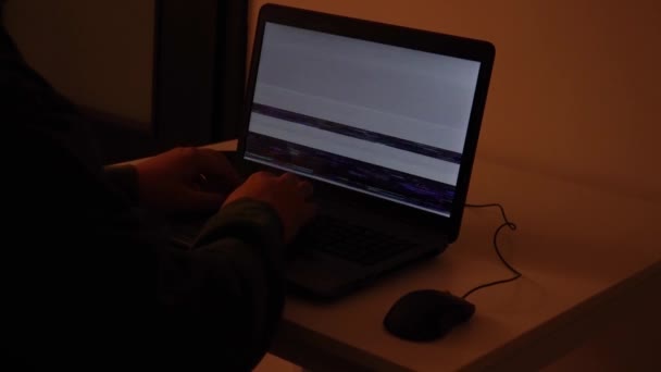 開発者がノートパソコンの暗室でコーディングするときに グリッチがコード雨に変わる — ストック動画