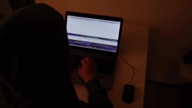 Bir aksaklık kod yağmuruna dönüştüğünde geliştirici dizüstü bilgisayardaki karanlık bir odada kodlama yapıyor