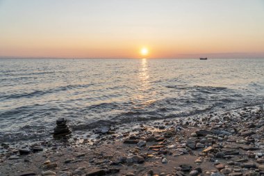 Gün batımında denizde bir yığın kaya.