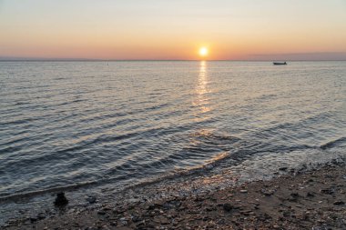 Gün batımında denizde bir yığın kaya.