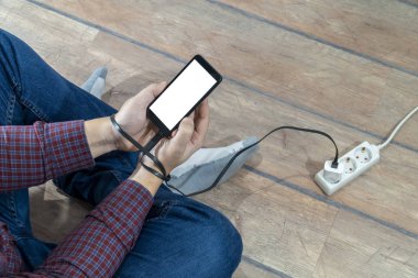 Elektrik bağımlılığı kavramı. Telefona bağlı bir adam...