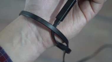 Modern problem kavramı. Elinde boş ekranlı cep telefonu olan bir adam elektrik bağlantısına bağlı. Eller şarj kablosuna bağlı..