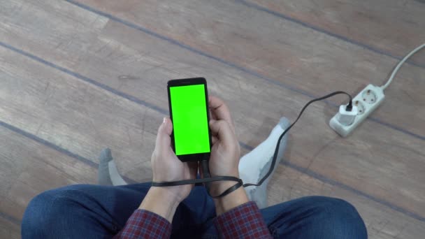 現代の問題概念 電気カプラーに接続された空白の画面を持つ携帯電話を持っている男 充電ケーブルで手を結ぶ — ストック動画