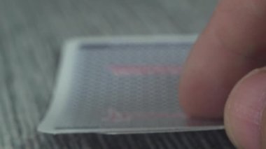 Düşük açılı, yakın plan bir erkek eli kumarhane masasından kartları alıp gösteriyor.