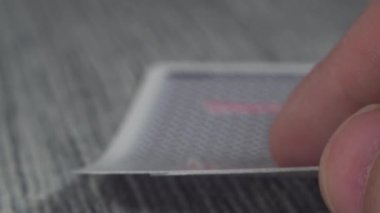 Düşük açılı, yakın plan bir erkek eli kumarhane masasından kartları alıp gösteriyor.