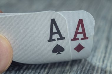 Düşük açılı, yakın plan bir erkek eli kumarhane masasından kartları alıp gösteriyor.