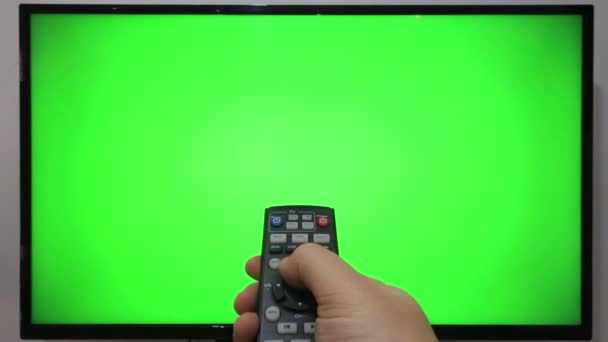 Persona Apuntando Televisor Remoto Pulsando Botones Delante Televisor Con Pantalla — Vídeos de Stock