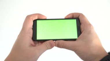Beyaz arkaplanda yatay pozisyonda boş ekranlı bir akıllı telefonu tutmak. Bir video konsepti izlemek.