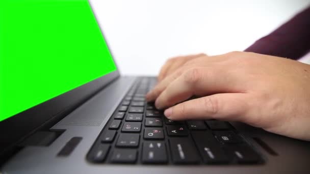 白い背景に隔離されたノートパソコンに入力する男の低角度ビュー — ストック動画