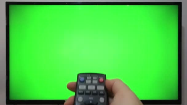 Особа Яка Вказує Телевізійні Віддалені Натискаючі Кнопки Перед Телевізором Зеленим — стокове відео