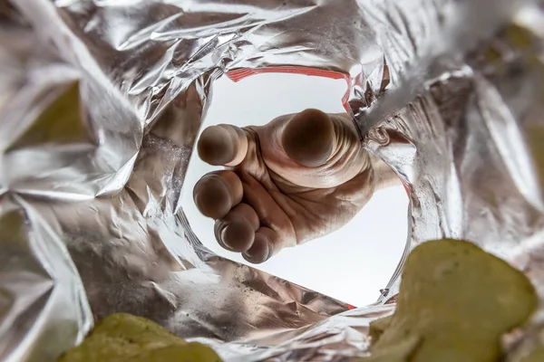 Креативный Вид Изнутри Мешка Картофельных Чипсов Рукой Тянущейся Чипсом — стоковое фото