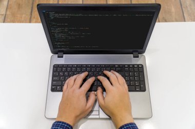 Ev kavramından çalış. Dizüstü bilgisayarda kod yazan bir programcının görünümünün üstünde.