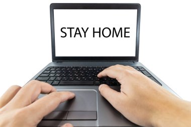 Bilgisayarda çalışan bir kişinin ekranda evde kalma mesajı ile düşük açılı görüntüsü
