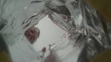 Yaratıcı açı konsepti. Bir paket cipse uzanan ve bir cips alan adam..