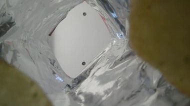 Yaratıcı açı konsepti. Bir paket cipse uzanan ve bir cips alan adam..