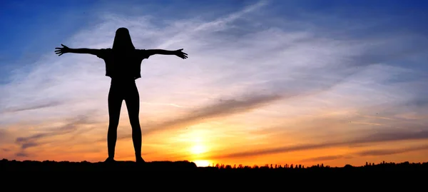 Freie, glückliche Frau, die Arme hebt und die Sonne im Hintergrund bei Sonnenaufgang beobachtet, glückliches Mädchen. Silhouette eines Mädchens bei Sonnenuntergang, das auf dem Hintergrund des Sonnenuntergangs springt — Stockfoto