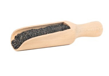 Tahta kepçeyle siyah susam, beyaz arka planda izole edilmiş.