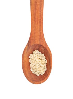 Beyaz arka planda susam tohumlu koyu ahşap kaşık, üst manzara.