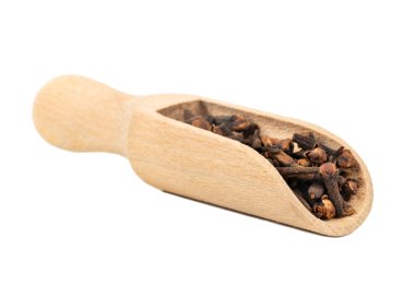 Beyaz bir arka plan üzerinde ahşap bir kepçe kuru karanfil