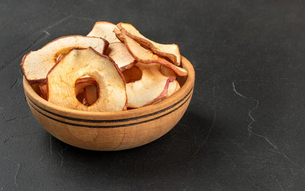 在深色背景下的木制碗里放苹果片 — 图库照片