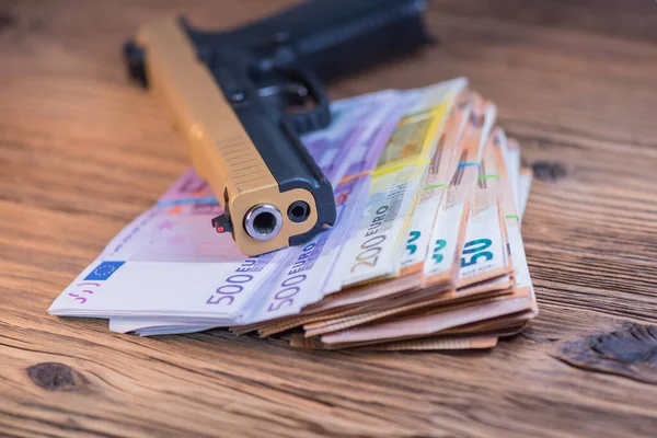 Black and gold gun pistol and money euros background