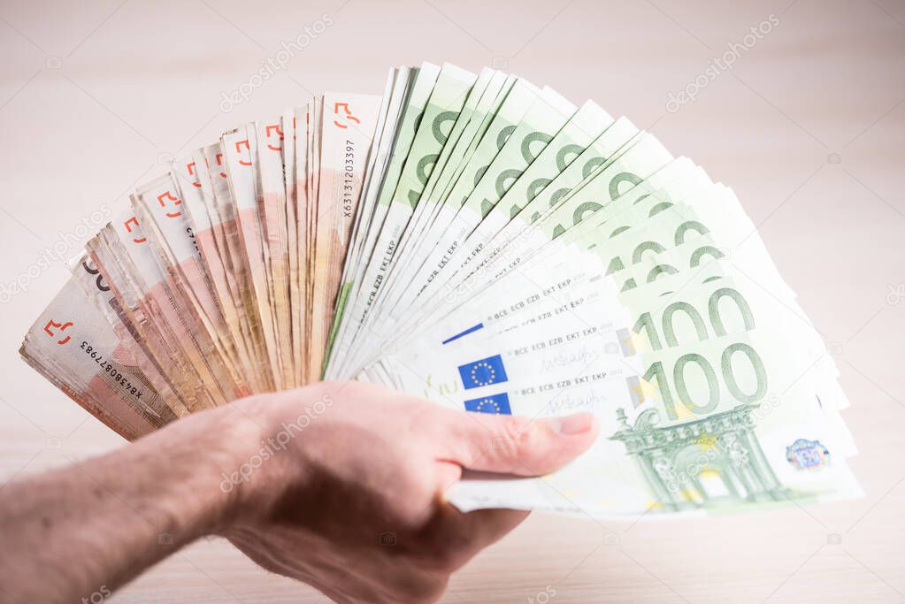 Man holding paper money - euros in the hand