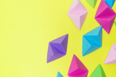 Sarı zemin üzerine parlak origami tetrahedrons kopya alanı sol tarafında ile soyut kompozisyon.