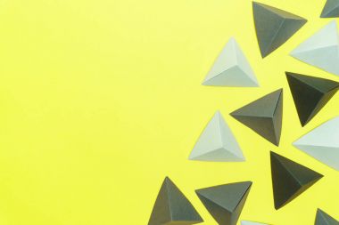 Origami gri ve siyah tetrahedrons kopya ile sarı arka plan üzerinde sol taraftaki uzay.