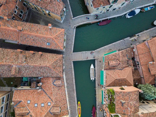 Bird view aerial photo of Venice with channels, boat and roofs.
