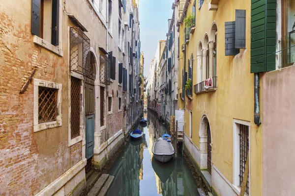 Вузький венеціанський канал між різнокольоровими будинками з човни. — стокове фото