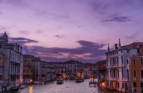 Pôr-do-sol incrível em Veneza sobre o Grande Canal com edifícios típicos venezianos, luzes de iluminação e barcos . — Fotografia de Stock