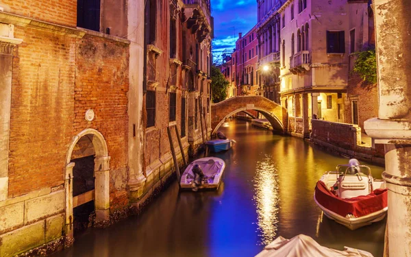 Venecia por la noche con barcos en canales, luces y edificios típicos venecianos . — Foto de Stock