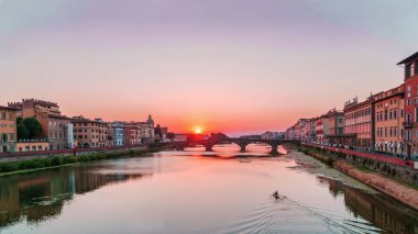 Günbatımı Floransa'da Arno Nehri ve yalnız kanocu nehirden aşağı gidiş üzerinde.