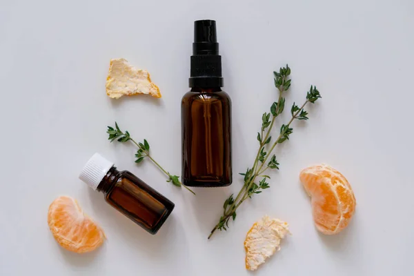 Organic products flat lay photo with glass bottles, fresh thyme herb and citrus fruit, horizontal orientation.