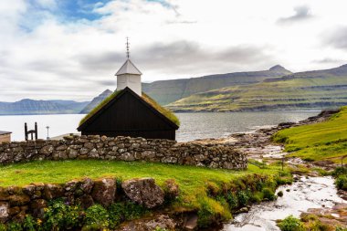 Fiyort 'un önünde çim çatılı ahşap kilise. Funningur Köyü, Faroe Adaları, Danimarka.