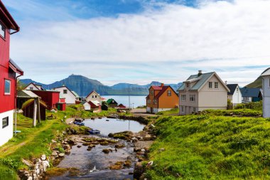 Gjogv köyünün renkli evleri ve fiyorda akan küçük bir nehir. Faroe Adaları, Danimarka.