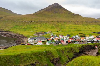 Gjogv köyünün arka planında sıradışı dağ manzarası var. Faroe Adaları, Danimarka.
