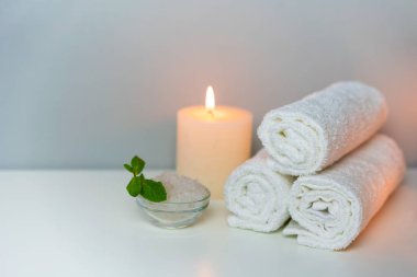 Mum, havlu yığını ve banyo için deniz tuzu içeren Spa konsepti fotoğrafı..
